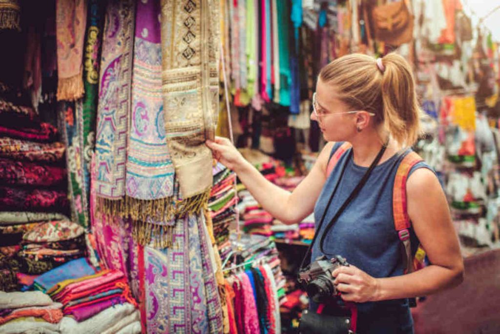 young happy woman discovers gifts market while travelling